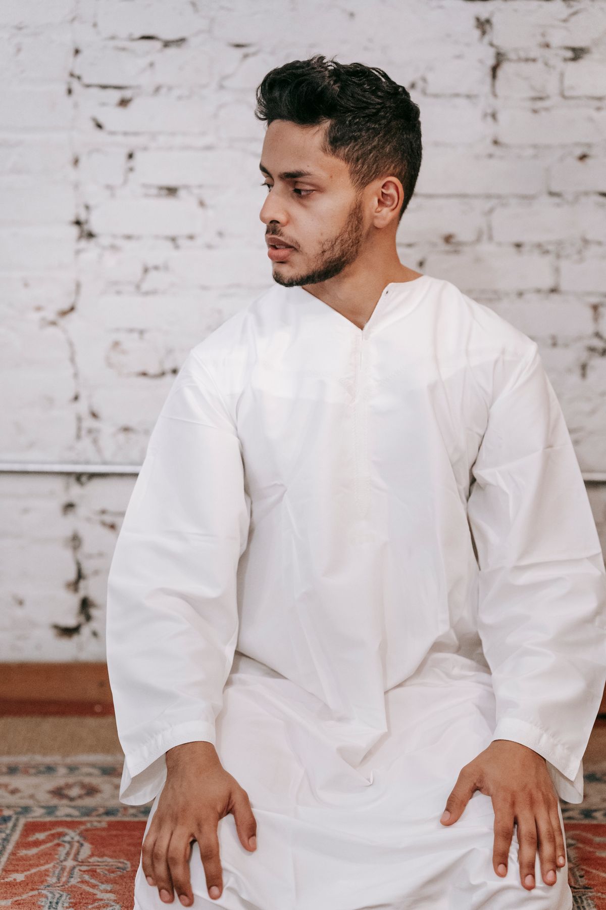 A young Muslim man in a white thobe